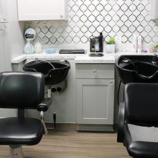 Modern hair salon interior with styling chairs and washing stations.