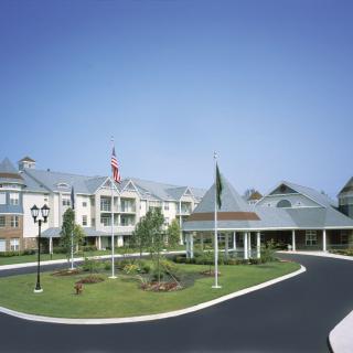 A large building with a circular driveway and flags at the entrance.