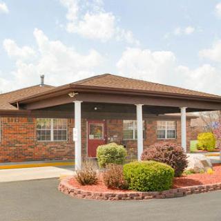 A welcoming brick building with landscaped grounds and a covered entrance.