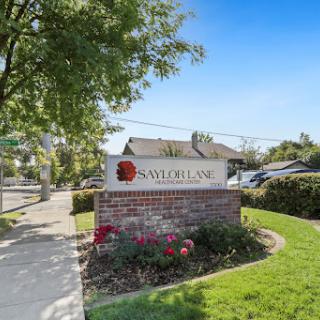 A welcoming sign for a residential community, surrounded by well-maintained landscaping and clear blue skies.