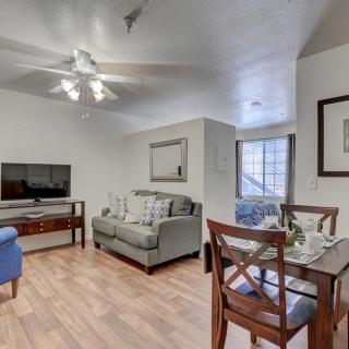 A cozy living room with a sofa, dining table, and television on a wooden floor.