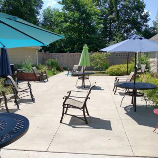 A sunny outdoor patio with tables, chairs, and colorful umbrellas.