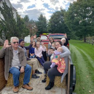 A group of people enjoying a hayride through scenic surroundings.