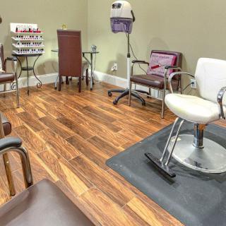 A stylish and well-equipped beauty salon with modern chairs and hardwood flooring.