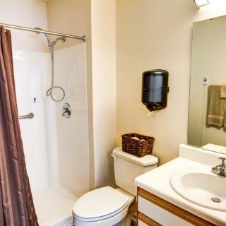 A clean and organized bathroom featuring a shower, sink, and toilet.