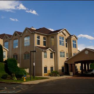 A modern hotel building with large windows, set against a clear blue sky.