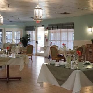 A spacious and elegantly designed dining area, featuring well-set tables and comfortable seating.