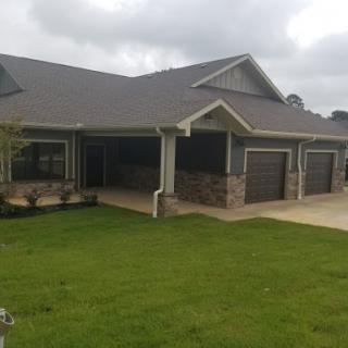 A beautiful single-story house with a well-maintained lawn and multiple garages.