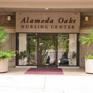 Entrance to Alameda Oaks Nursing Center, featuring clear signage and potted plants.
