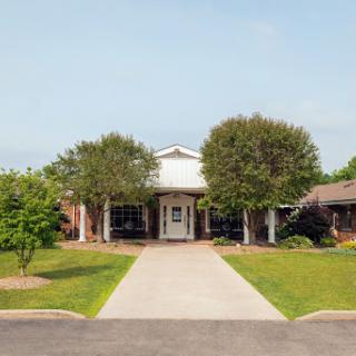A welcoming entrance to a residential building surrounded by lush greenery.