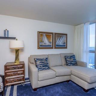 A cozy living room with a sectional sofa, nautical-themed decor, and ample natural light.