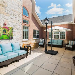 A spacious patio with comfortable outdoor seating and umbrellas on a sunny day.