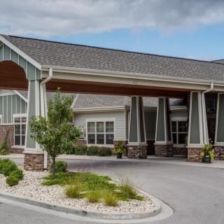 A well-designed building with a covered entrance and landscaped surroundings.