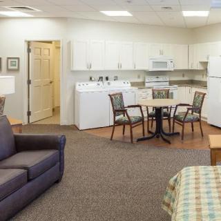 A cozy apartment interior featuring a living room, kitchen, and dining area.