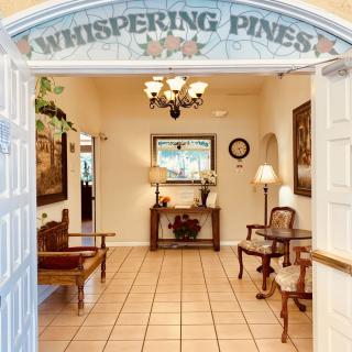 Welcoming entrance to Whispering Pines with elegant decor and comfortable seating.