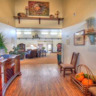 A warmly decorated hallway with autumn-themed elements and wooden flooring, leading into a living area.