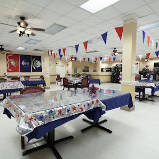A spacious dining area decorated with banners and ready for an event.
