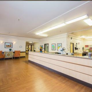 A welcoming reception area in a healthcare facility, featuring comfortable seating and informative wall art.