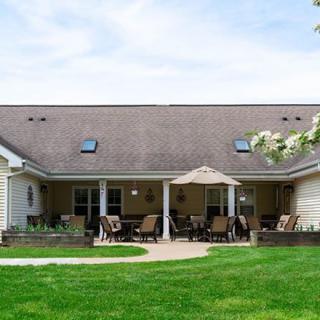 A cozy residential backyard featuring a patio with outdoor furniture and a well-kept lawn.