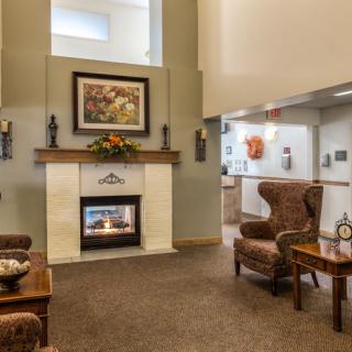 A cozy living room featuring a central fireplace, comfortable armchairs, and elegant decor.