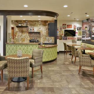 A cozy cafe with modern decor, featuring a bar and seating area.