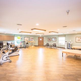 A spacious and well-lit therapy room equipped with exercise machines, ideal for rehabilitation.