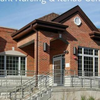 A brick building with a prominent entrance and stairs leading up to the door.