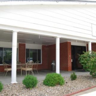 An outdoor porch area with seating and landscaping.