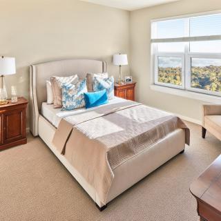 A well-lit bedroom with elegant decor and a scenic view from the window.