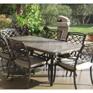 Outdoor patio furniture set with table and chairs in a garden setting.