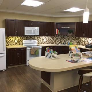 A modern kitchen with a central island, dark cabinets, and a stylish backsplash.