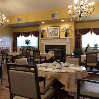 An elegantly decorated dining room with chandeliers and neatly arranged tables and chairs.