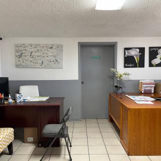A small office space with desks, chairs, and decorative artwork on the walls.