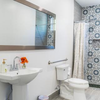 A modern bathroom featuring a stylish sink, clean toilet, and decorative wall tiles.