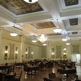An elegant dining hall with ornate ceilings and chandeliers.