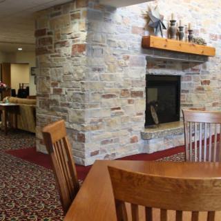 A cozy room featuring a stone fireplace and wooden furniture.