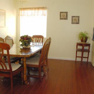A cozy dining room with a wooden table and chairs, complemented by decorative elements on the walls and floor.