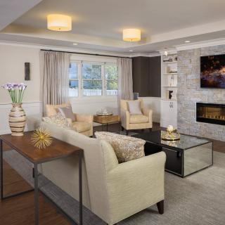 A modern and cozy living room featuring neutral-toned furniture, a fireplace, and stylish decor.