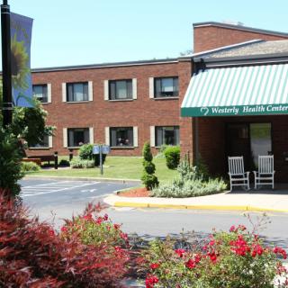 The entrance of a healthcare facility with well-maintained landscaping.