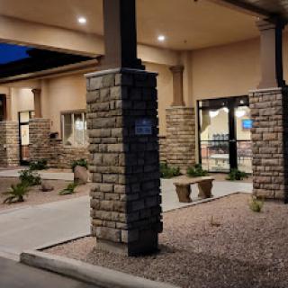 A well-lit entrance of a stone-accented building at night.