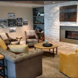 A cozy living room with modern decor, featuring a fireplace and comfortable seating.