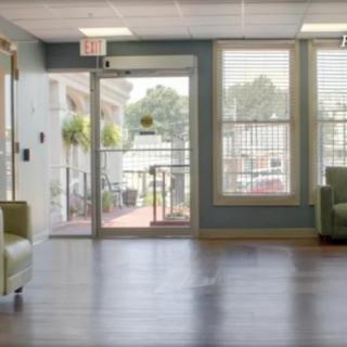 A modern waiting room with large windows and comfortable seating.