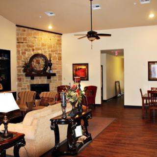 A cozy living room featuring elegant furniture and a stone accent wall.