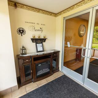 A cozy interior entrance with decorative wall art and a wooden console table beside a glass door.