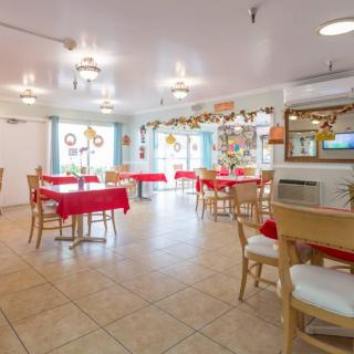An indoor dining area with tables and chairs, decorated for the holiday season.