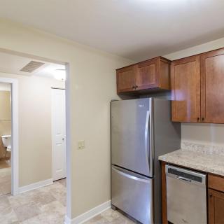 A modern kitchen featuring stainless steel appliances and wooden cabinets.