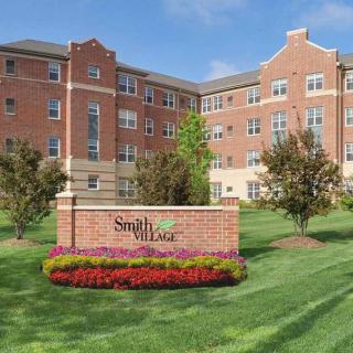 A residential building with a landscaped lawn and a sign reading 'Smith Village'.