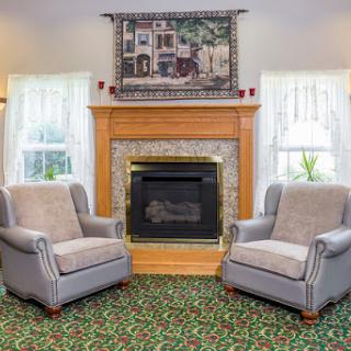 A cozy living room featuring two comfortable chairs and a fireplace, perfect for relaxing.