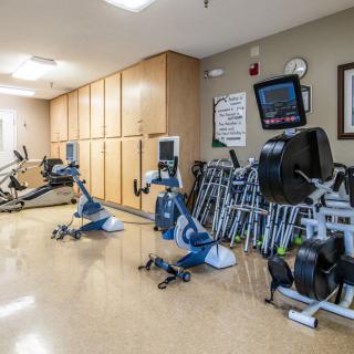 A well-equipped gym with various exercise machines and stationary bikes arranged neatly.