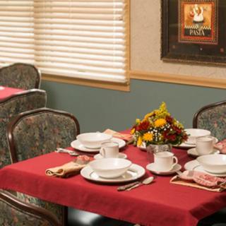 A neatly set dining table with floral centerpiece in a cozy restaurant.